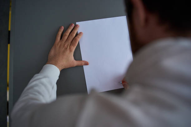 istock a man writes on a white sheet of paper 1253248090