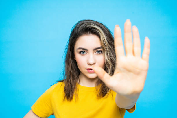 istock Young pretty woman make stop gesture isolated on blue background 1253250992