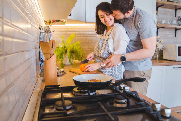 istock lovely couple hugging on the kitchen while cooking breakfast 1253251360