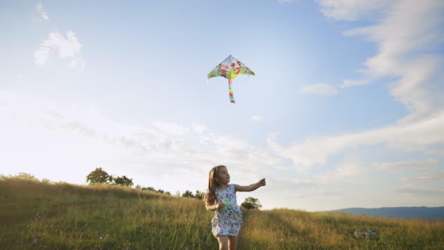 Little carefree girl flying a kite