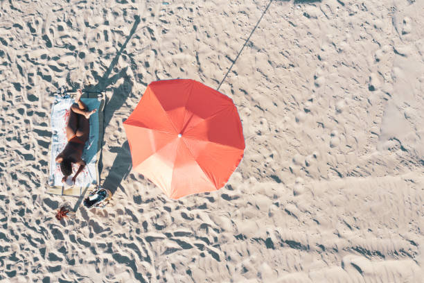 istock Young woman sunbathing at the beach 1253252770