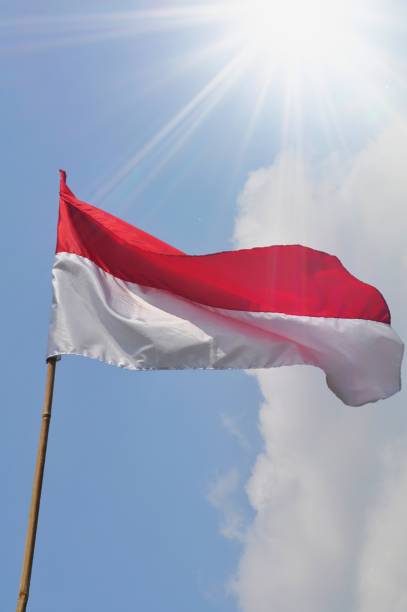 istock Indonesian Flag waving on blue sky background 1253252899