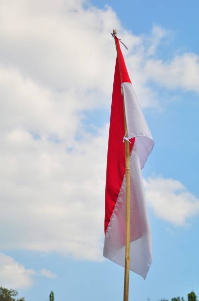 Indonesian Flag waving on blue sky background. Red and White flag. Independence day of Indonesia