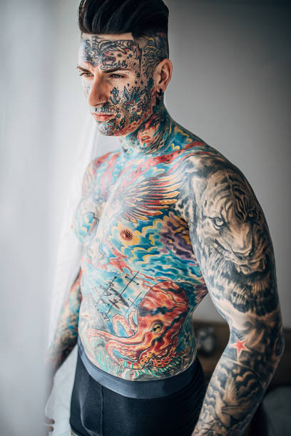 istock Shirtless man with whole body covered in tattoos 1253253266