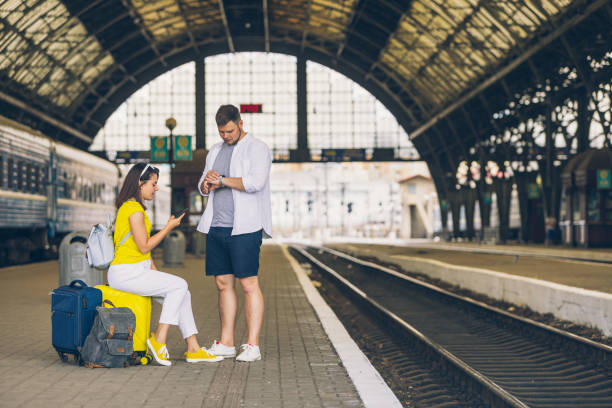 istock couple waiting for train at railroad station 1253253483