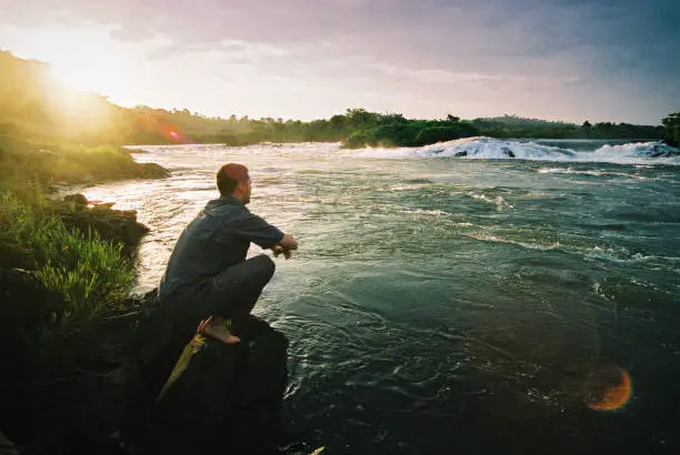 Photo of Young Man staring at the Source of the River Nile