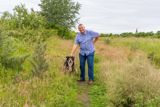 istock Man on grassland with border collie 1253255926