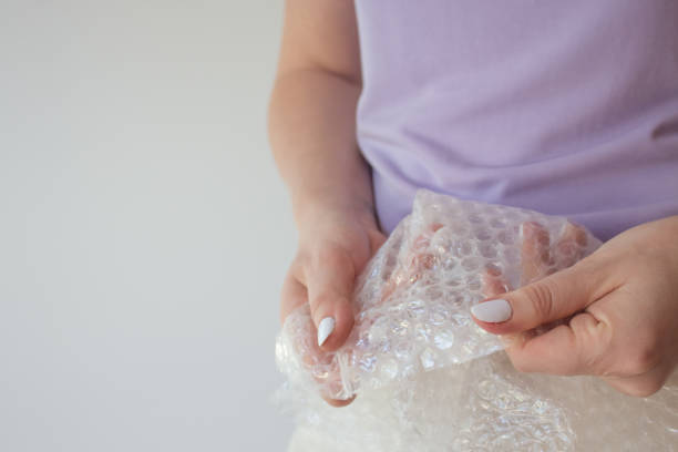 istock Cellophane film for packaging with air in female hands with copy space. bubble pack Packing Close Up, Copy Space 1253256025