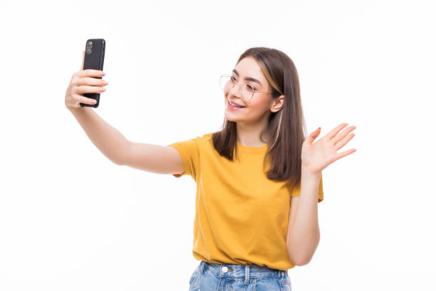 istock Girl waving on the smart phone while during a video call on a white background 1253256054