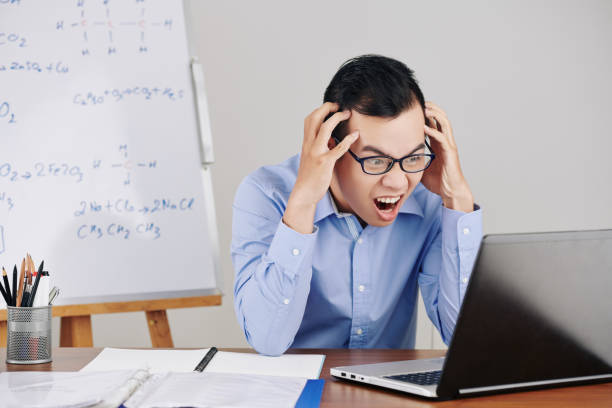 istock Frustrated teacher looking at opened laptop 1253256303