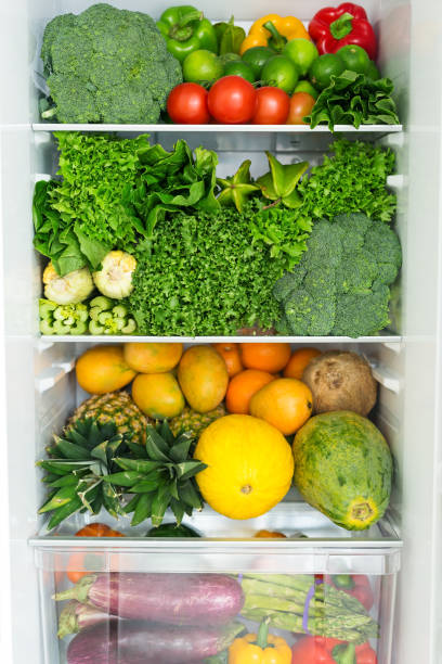 geöffneter kühlschrank voller frischer, bunter früchte und gemüse - refrigerator healthy eating mango fruit stock-fotos und bilder