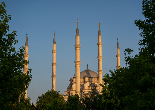 Sabanci Central Mosque in Adana is the largest mosque in Turkey with six minarets. Image taken from Merkez Park on a bright morning light and cloudy sky