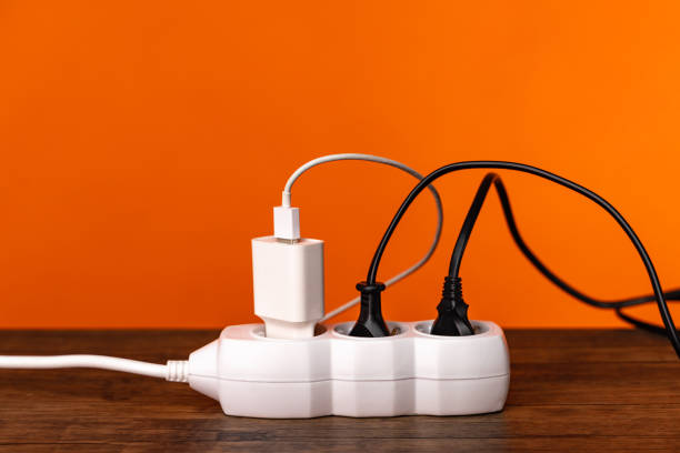 White extension cord with three plugs on orange background