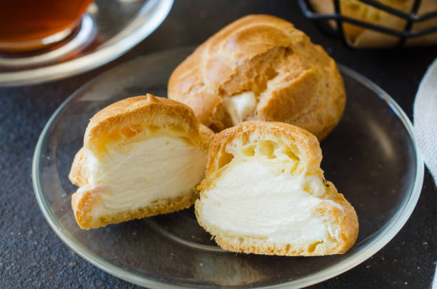 a massa de funções caseiras recheadas com creme. eclairs com creme, sobremesa francesa. - cream filling - fotografias e filmes do acervo