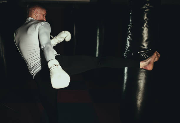 istock Young man kicking a bag on a kick box training 1253263607