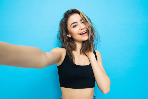 istock Young woman taking a selfie isolated on blue ground 1253263736