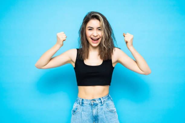istock Young girl make winner gesture standing isolated over blue background 1253263839