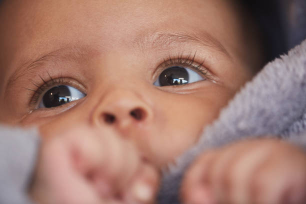 Cute Baby Eyes Close Up Close up portrait of cute mixed-race baby sucking thumb with focus on big hazel eyes with long lashes, copy space biracial newborn stock pictures, royalty-free photos & images