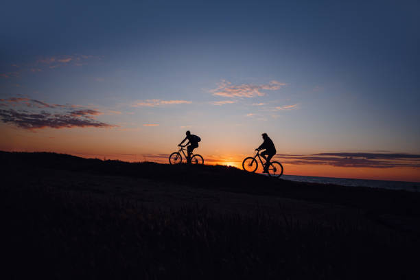 istock two friends on bikes enjoy a beautiful sunset 1253265401