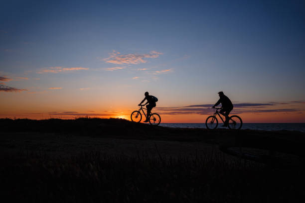 istock two friends on bikes enjoy a beautiful sunset 1253265451