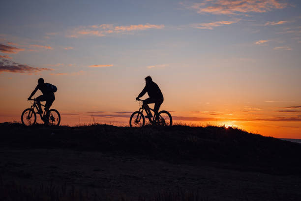 istock two friends on bikes enjoy a beautiful sunset 1253265452