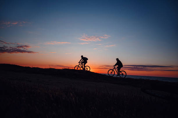 istock two friends on bikes enjoy a beautiful sunset 1253265532