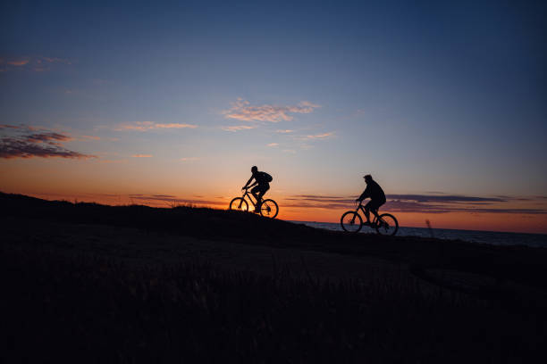istock two friends on bikes enjoy a beautiful sunset 1253265625