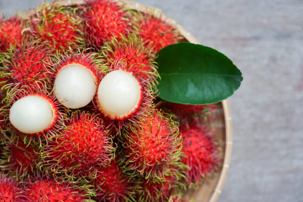 rouge rambutan doux et fruits de fraîcheur du jardin de thaïlande dans le fond de panier - ramboutab photos et images de collection