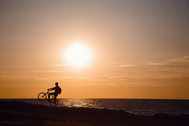 istock Silhouette of cyclist in motion at beautiful sunset. 1253265985