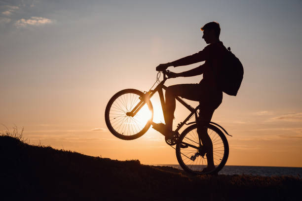 istock Silhouette of cyclist in motion at beautiful sunset. 1253266033