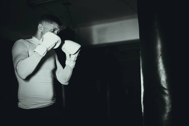 istock One young athletic man punching a bag on a kick box training in the gym 1253267784