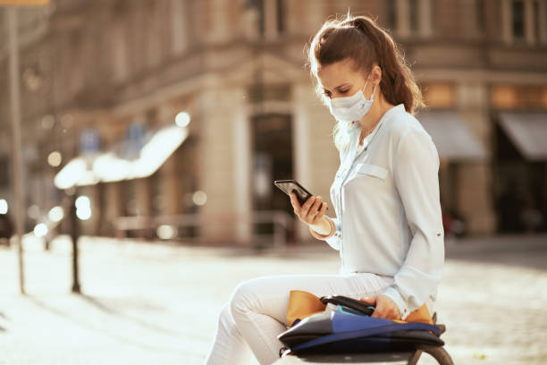 istock woman in blue blouse using smartphone app outdoors in city 1253269480