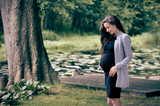 Beautiful young pregnant woman walking in a public park