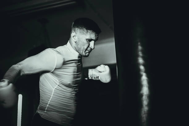 istock Athletic man punching a bag on a kick box training in the gym 1253271352
