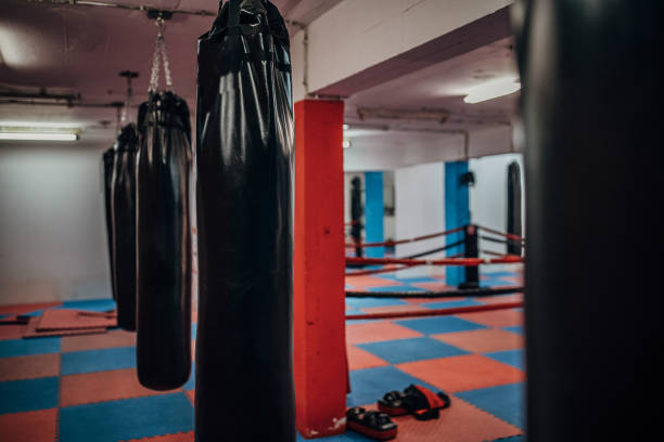 istock Boxing ring and several punching bags in the gym 1253271686
