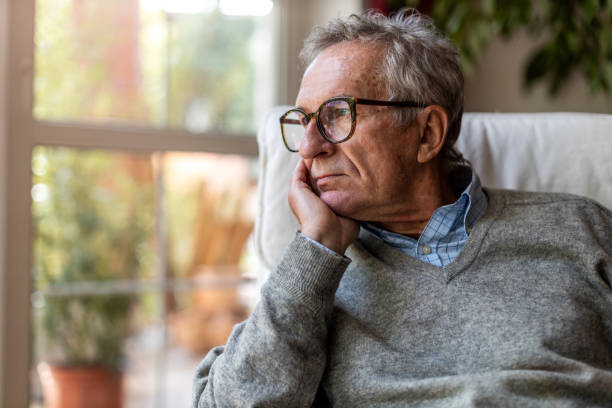 istock Senior man looking out of window at home 1253272865