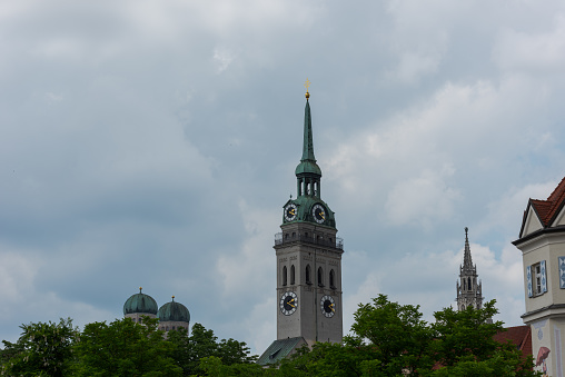 Tower of the Church of St. Peter in Munich with domes of the Frauenkirche