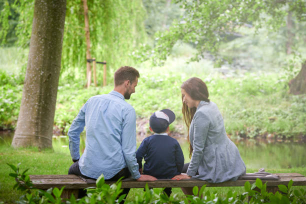 istock Family on bench in park 1253273023