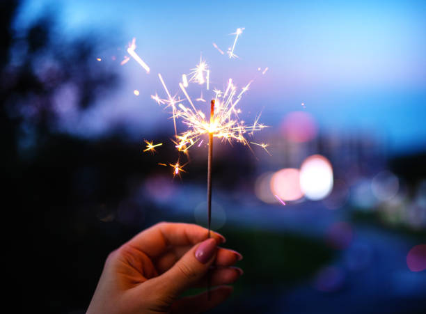istock Woman hands holding sparkler, evening time. 1253273550