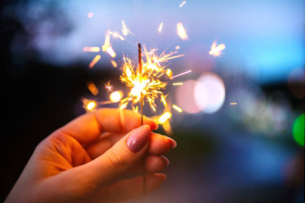 istock Woman hands holding sparkler, evening time. 1253273552