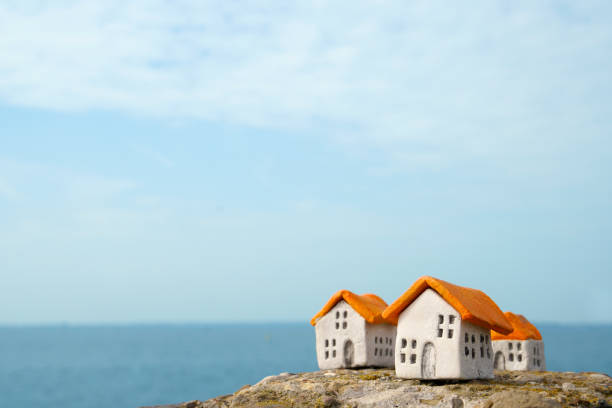 three little clay houses on the rocks near water copyspace - scale industry copy space special imagens e fotografias de stock