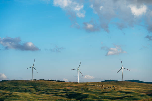istock Three high wind turbines in the field against the blue sky. 1253275688
