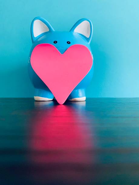 istock Blue piggy bank and red heart shape 1253276056