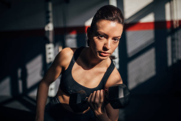 istock Fit woman training with dumbbell in gym 1253280658