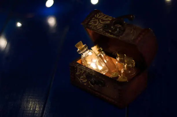 original bottle with lights inside in a box on a blue wooden background with copy space