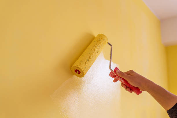 istock Workman painting the wall in yellow. 1253282158
