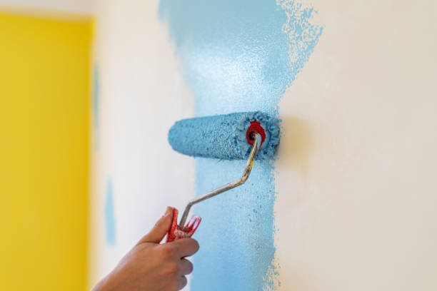 istock Workman painting the wall in blue. 1253282580