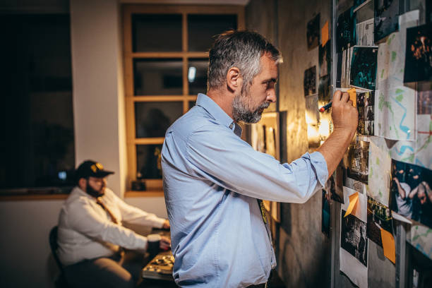 istock Two male detectives working on a murder case in the office 1253283901