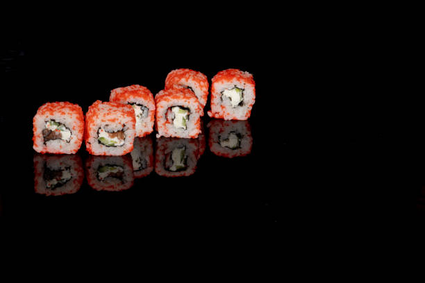istock Philadelphia roll with salmon, cheese and cucumber on a black background with reflection. Sushi Philadelphia 1253284502