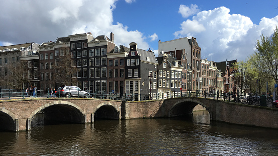 Amsterdam, Netherlands - 04 17 2016: Keizersgracht canal bridges in Amsterdam, Netherlands. Amsterdam \nis home to more than one hundred kilometres of canals, most of which are navigable by boat.